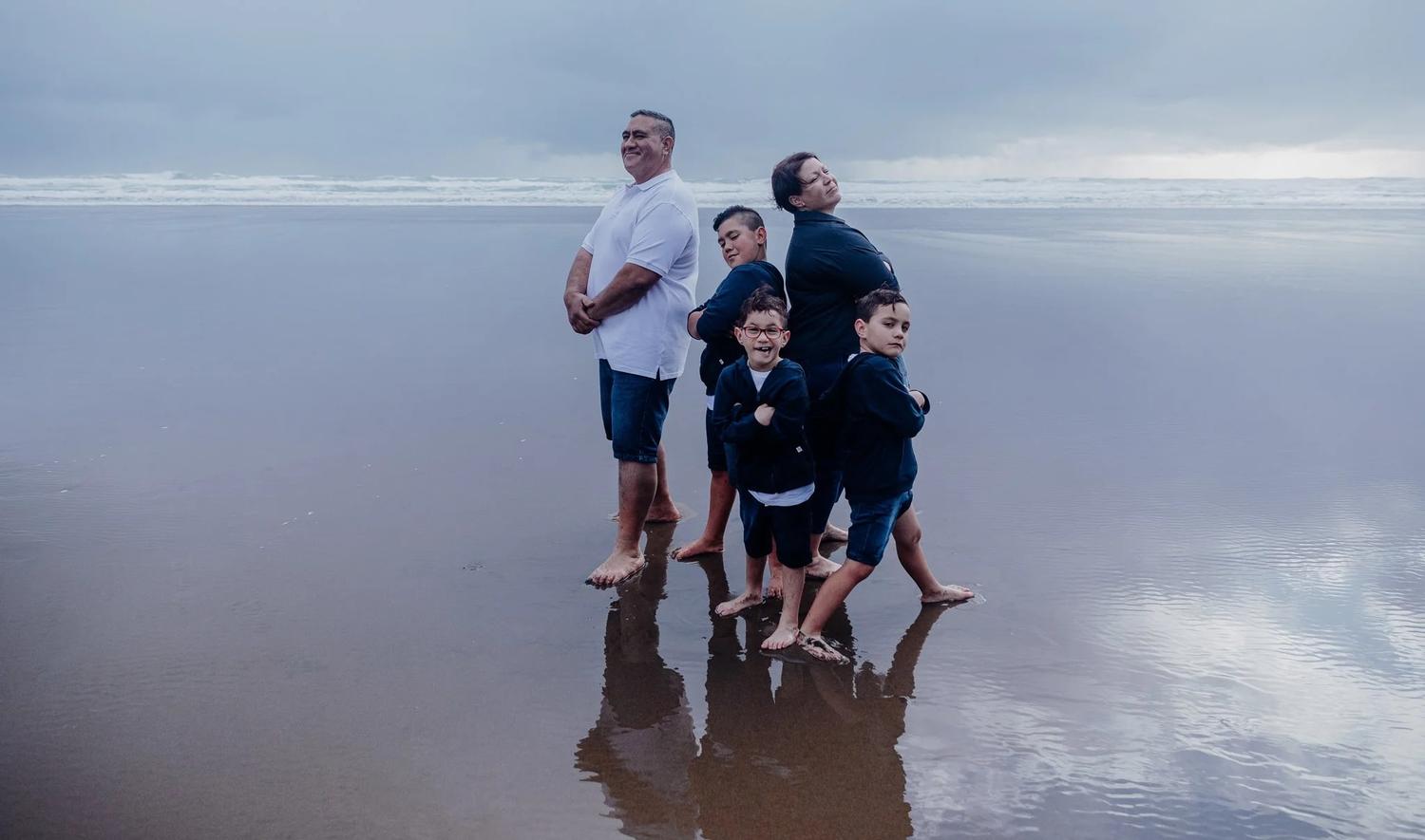 The family stands together on the beach on a misty day