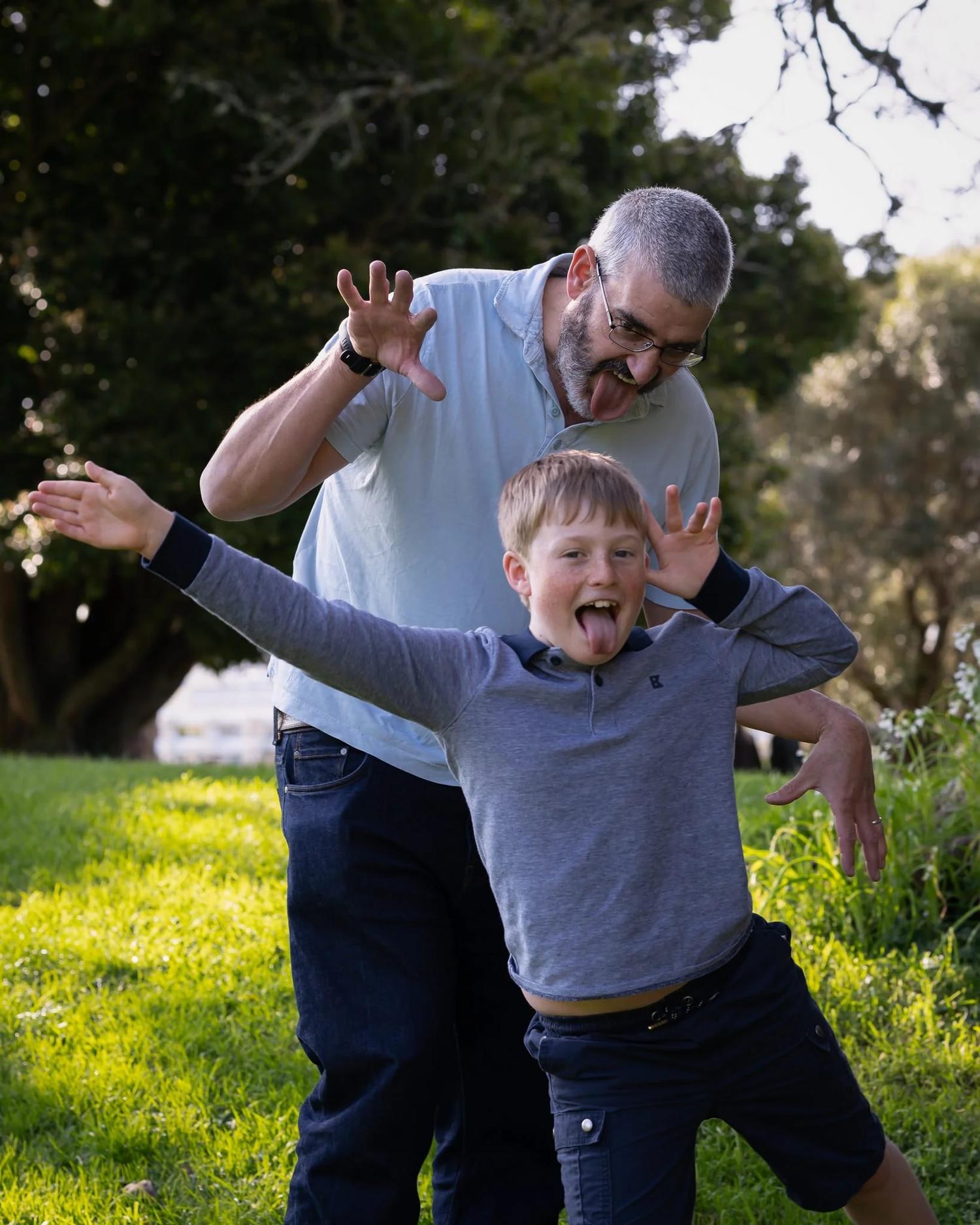 A father and son pull playful faces for the camera