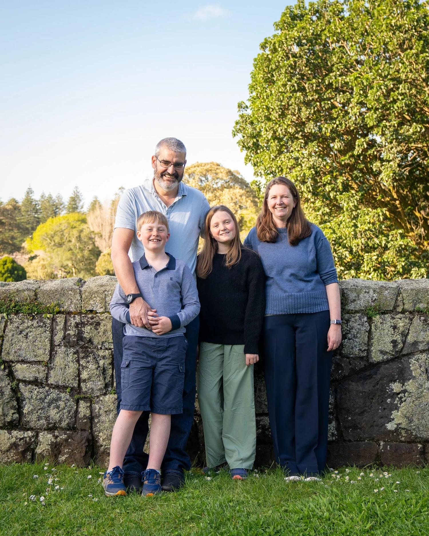 The family smiles in the late-afternoon sun