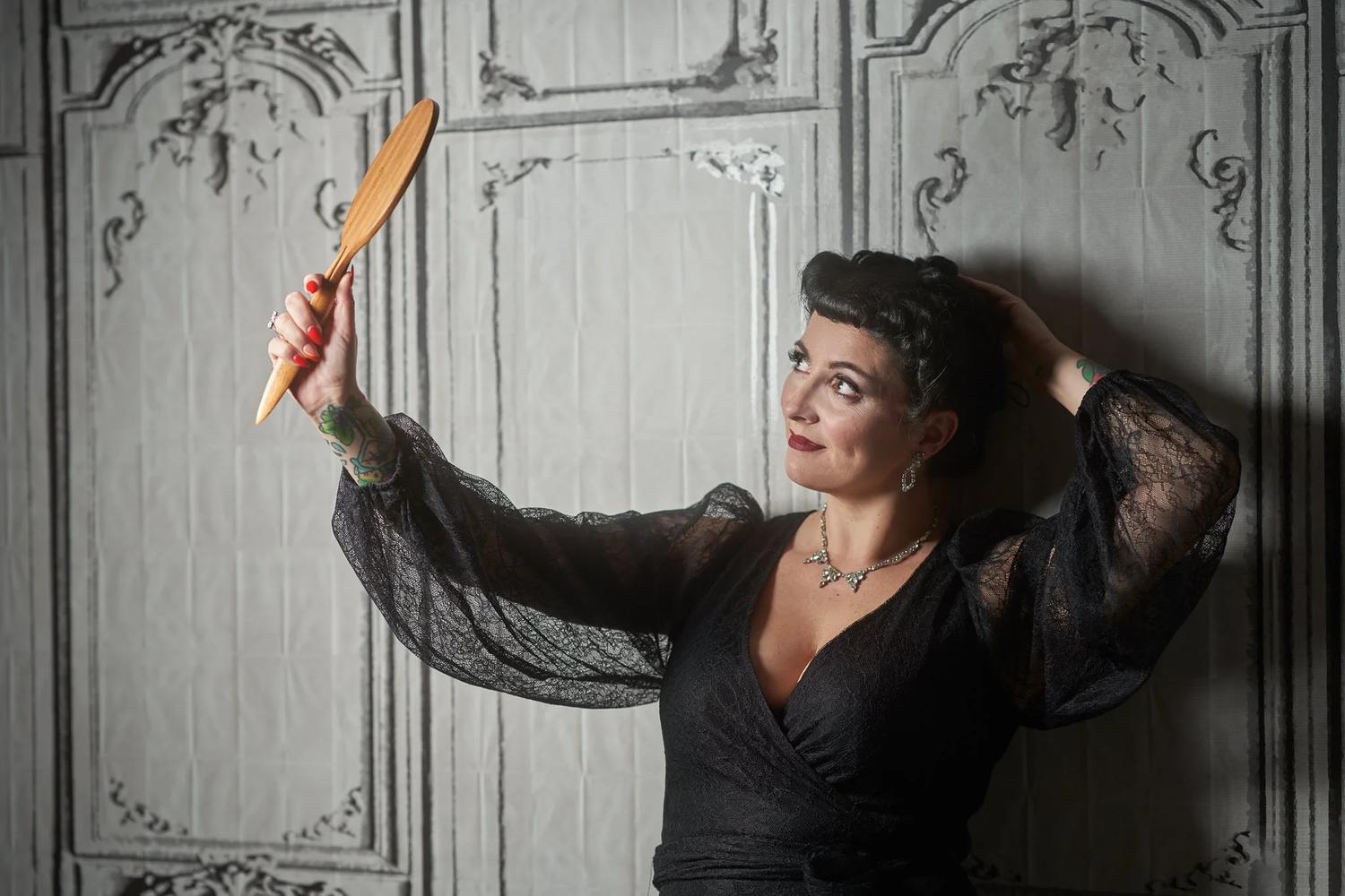 Viv holds a hand mirror up to admire her hair