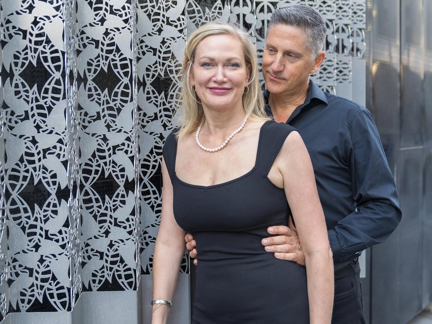 Couple posing in front of a patterned screen during a practice wedding shoot