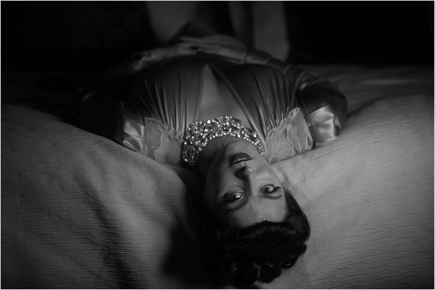Black and white photo of Viv lying upside down on a bed