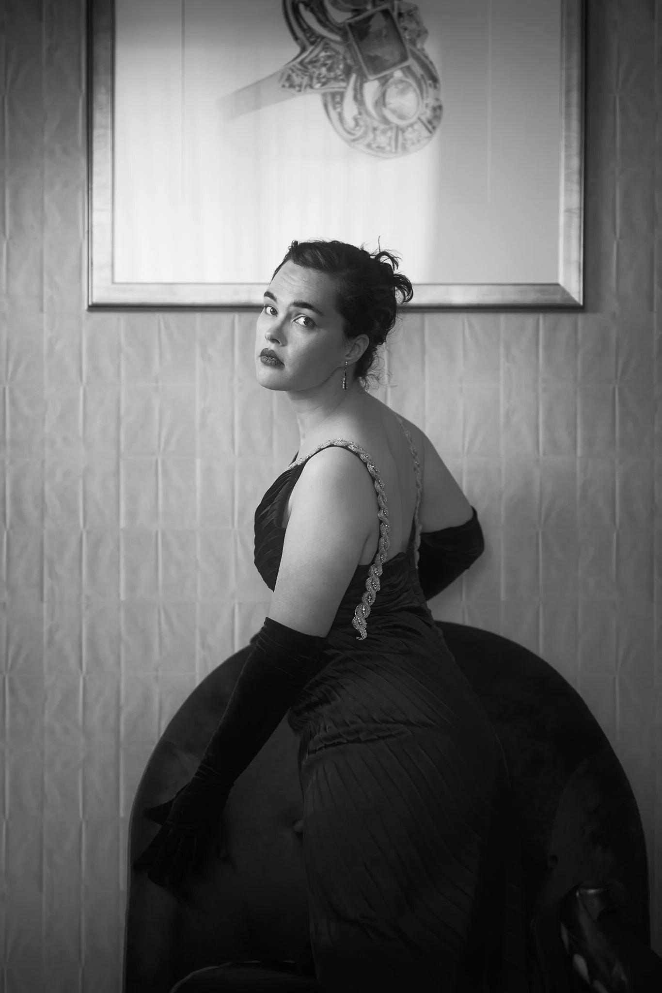 Black and white photo of Anita in a full black gown from behind