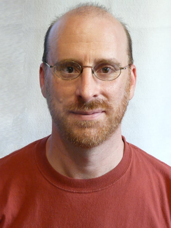 An image of a man wearing glasses, facing the camera