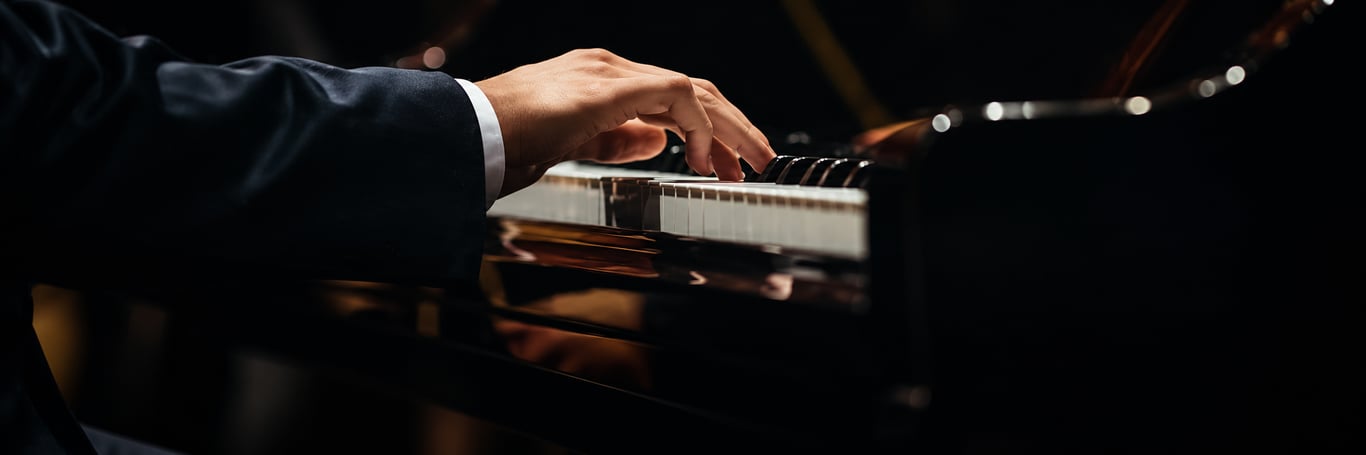 A pianist's hand playing a grand piano