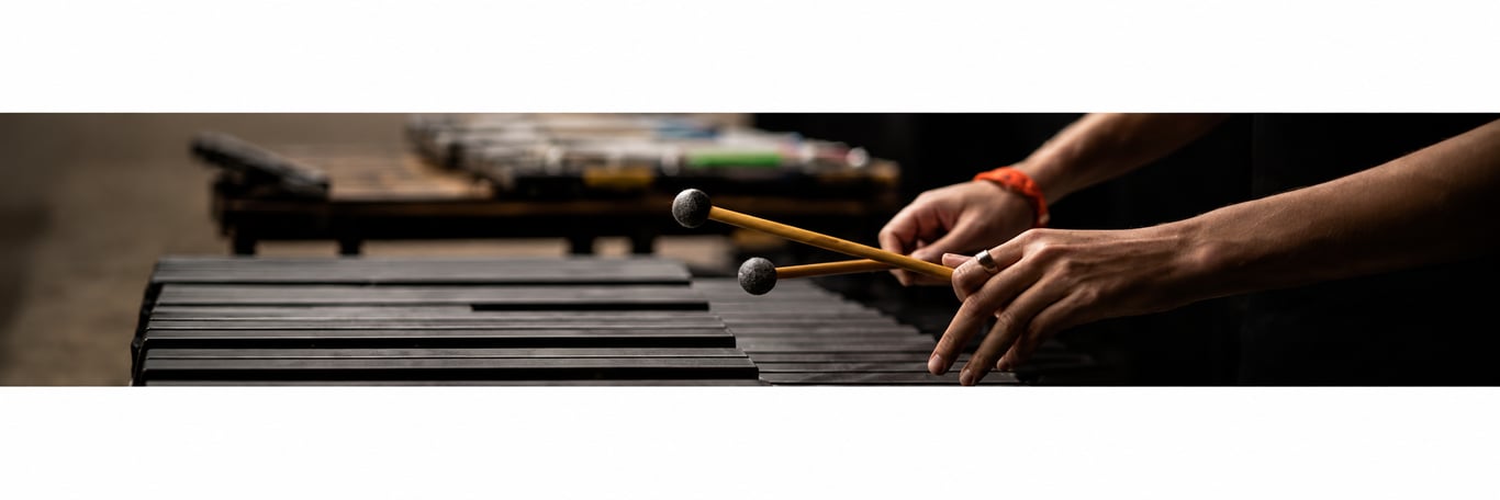 A percussionist's hands holding mallets over a marimba