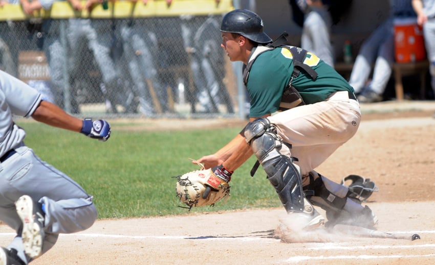 <who>Photo Credit: Lorne White/KelownaNow </who>Okanagan A’s catcher, Marcus Strother, gets set to receive a throw to the plate in Sunday’s first game of a doubleheader. The ball skipped in the dirt and the UBC Thunder runner scored on the play.