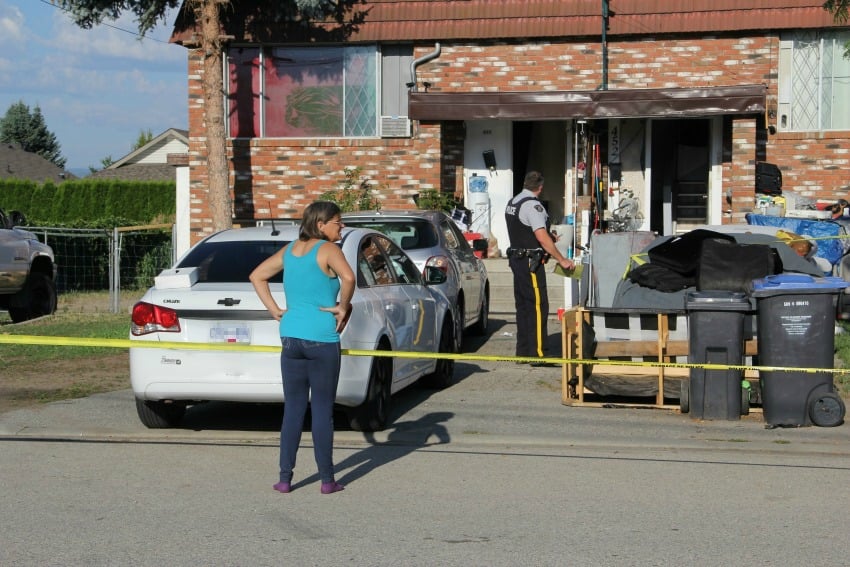 <who> Photo Credit: KelownaNow.com </who> The victim's neighbour waiting outside of her home.