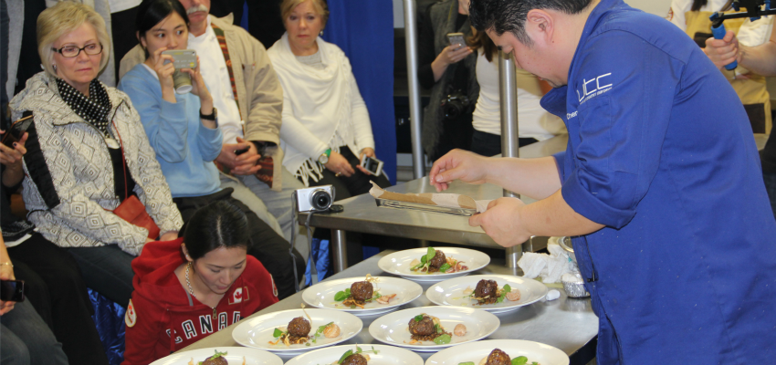 <who> Photo Credit: KelownaNow </who> B.C. Chef Alex Chen puts the finishing touches on his dish at the Black Box event. 