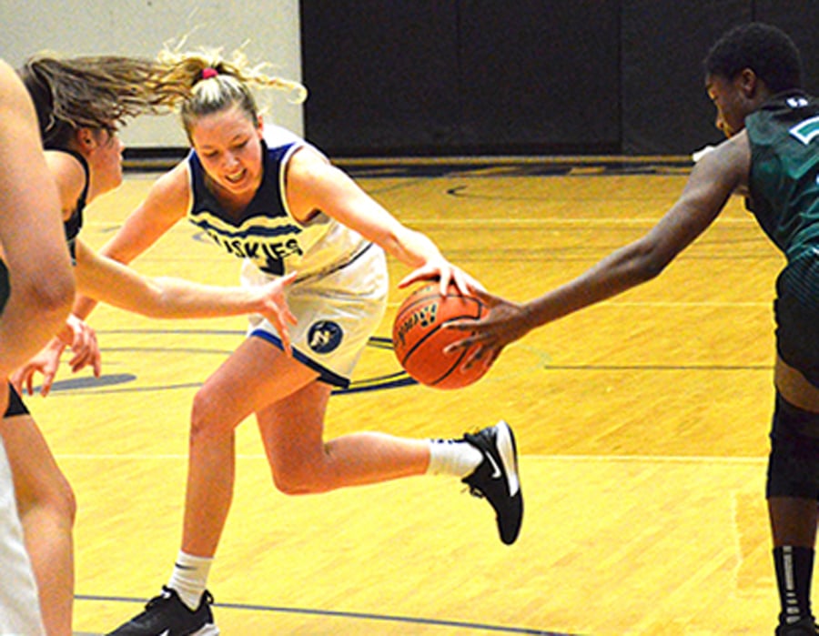 Lily Pink of the OKM Huskies fights for possession against the Christian Langley Lighting in semifinal play on Friday.