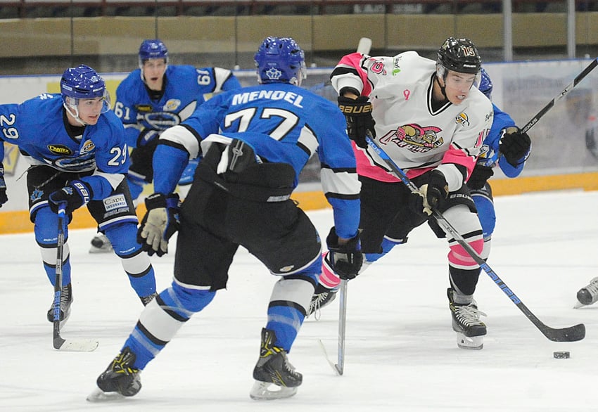 <who>Photo Credit: Lorne White/KelownaNow </who>Reed Gunville of the Warriors puts pressure on the Penticton Vees' defence, including Kelowna minor hockey product, Griffin Mendel. The Vees doubled the Warriors 6-3 with the help of three quick goals in the first period.