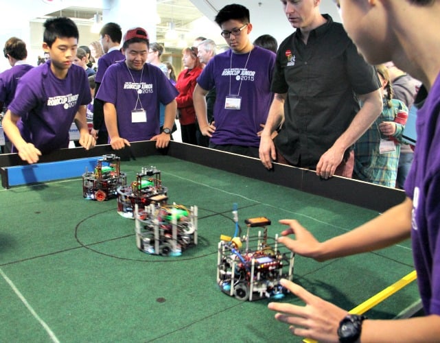 <who> Photo Credit: KelownaNow.com. </who> Team gearing up to take part in a robot soccer match. 