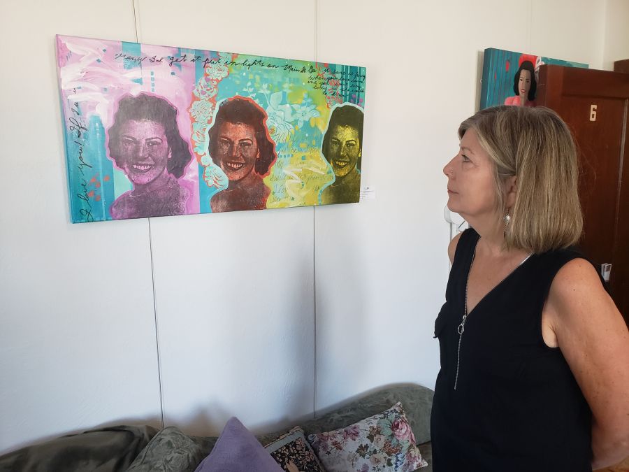 <who> Photo Credit: NowMedia </who> Deb Tougas peers at her favourite painting in the exhibit.