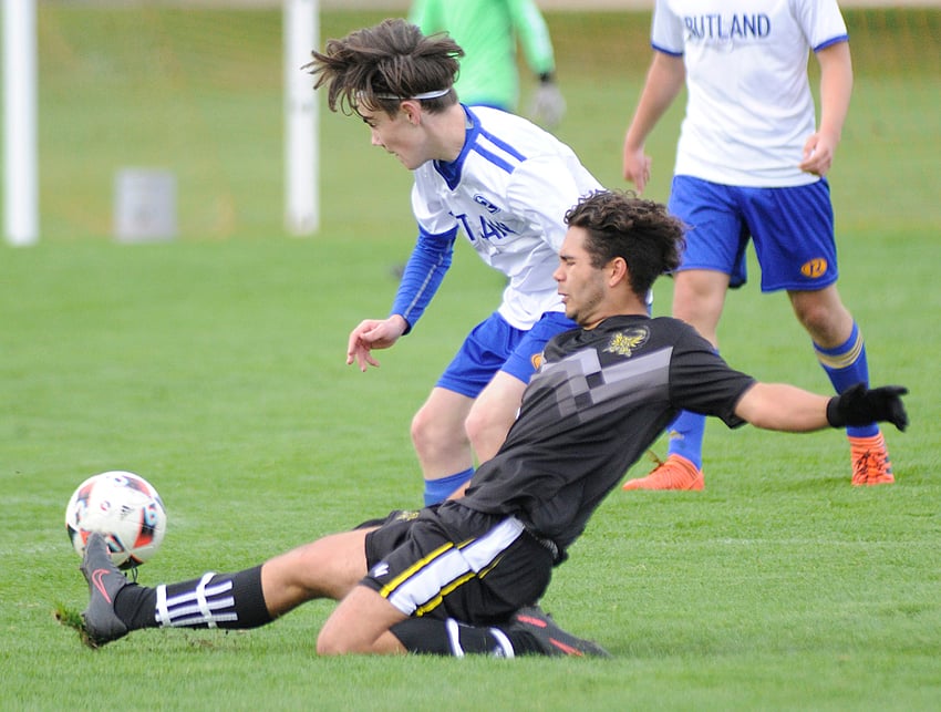 The Kelowna Owls' Adrian Delgado slides to put his foot on a loose ball in a battle with Rutland's Zack McInnis.