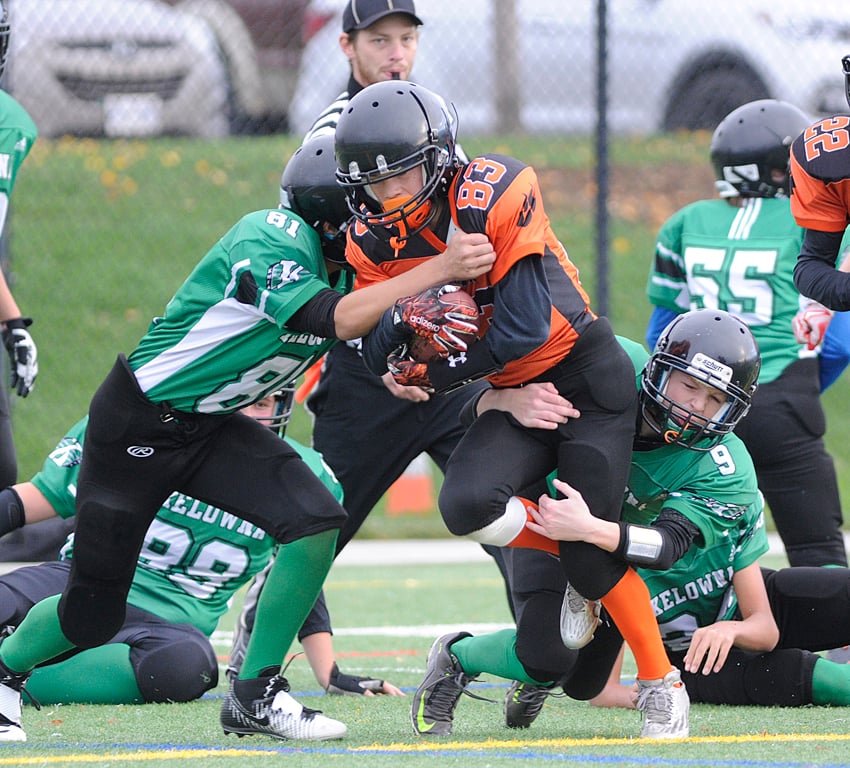<who>Photo Credit: Lorne White/KelownaNow </who>The Lions' Noah Gross is brought down by Zac Warren (9) and Kaenan Nemr (81) of the Kelowna Riders.
