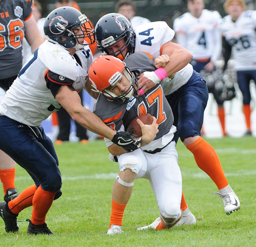 Rookie quarterback Matthew Mahler is brought down yard by a pair of Broncos in the second quarter.