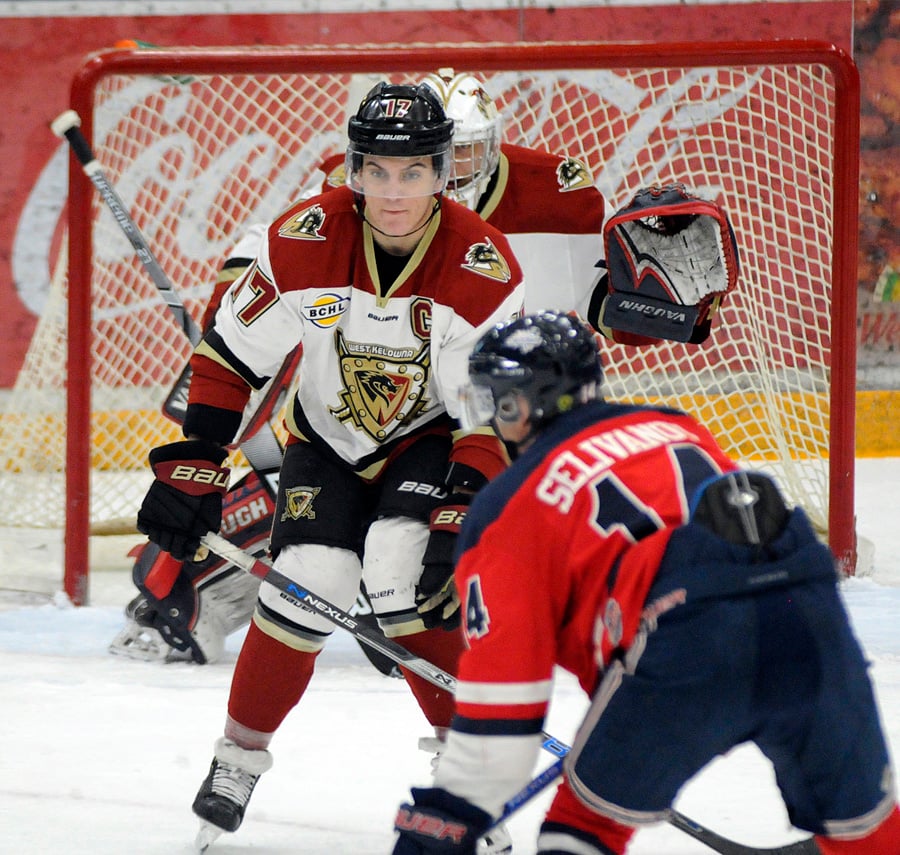 <who>Photo Credit: Lorne White/KelownaNow </who>Calvin Tilsley of the Warriors attempts to block a shot by the Capitals' Dimitri Mikrogiannakis in the first period. 