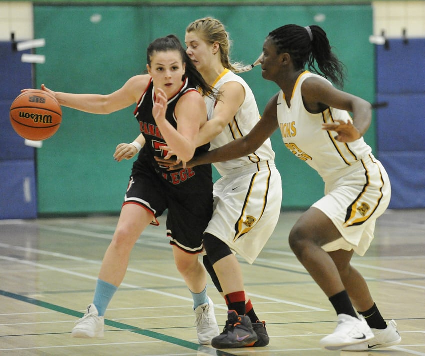 <who>Photo Credit: Lorne White/KelownaNow </who>The Coyotes' Rebekah Salway drives past a couple of Ambrose Lions in Saturday's OC victory.