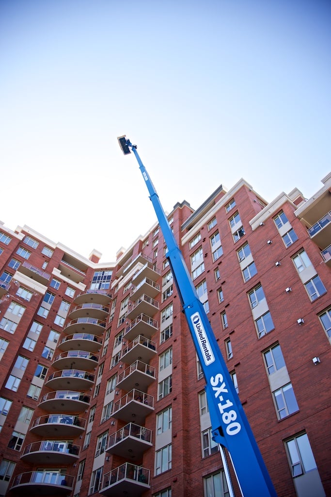 The 180-foot boom lift ascends towards the heights of the Centuria building.