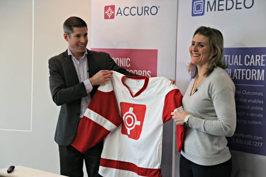 <who> Photo Credit: KelownaNow.com </who> Mike Checkley presents Hayley Wickenheiser with a new QHR Technologies jersey. 