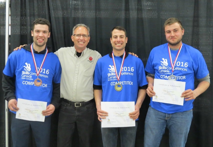 <who> Photo Credit: OKanagan College </who> OC Automotive Service students stand on the podium at Skills BC. From left to right: Hugo Beaumier-Martin (bronze), Jamie Bloomfield (OC instructor), Aaron Schmidt (gold), Dale Blumhagen (silver).