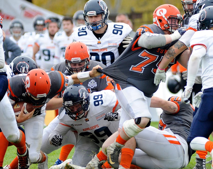 QB Matthe Mahler hangs on to teammate James Harney while driving forward in the second quarter.