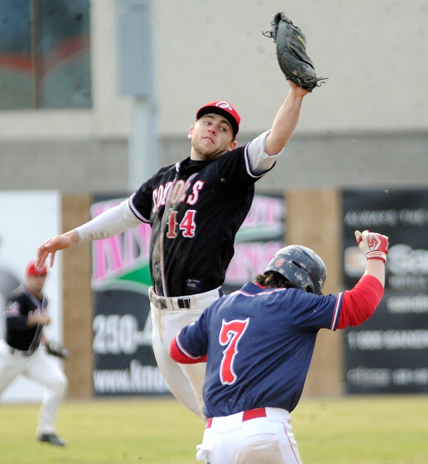 <who>Photo Credit: Lorne White/KelownaNow </who>OC Coyotes' first baseman, Jared Frew, leaps to grab a high throw as PBA's Dalton Wells approaches the bag. Wells was safe on the play.