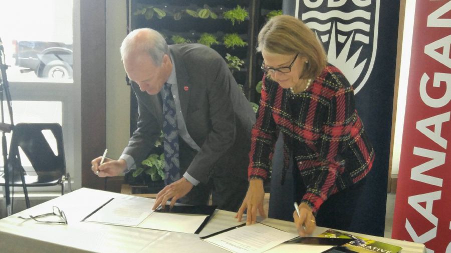 <who>Photo Credit: NowMedia </who>Okanagan College president Jim Hamilton and Dr. Deborah Buszard, deputy chancellor and principal of UBCO, officially sign the letter of co-operation that will see both institutions partner on numerous green energy initiatives, including establishing a Green Construction and Training Centre.