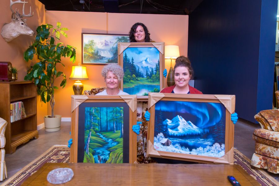 <who>Photo Credit: NowMedia</who> Gallery reps Carla O'Bee, Karen Walls, and McKaila Ferguson excitedly show off a trio of Bob Ross originals at Thursday's long-awaited unpackaging.