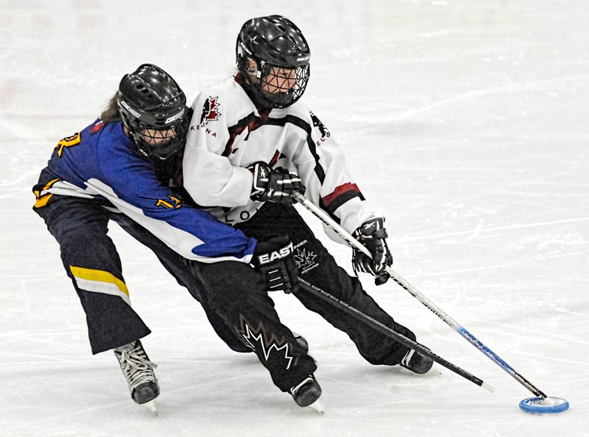 <who>Photo Credit: Lorne White/KelownaNow </who>Jordyn Cates of the Heat leans on Vernon's Brenna Beck before getting away a shot on net.