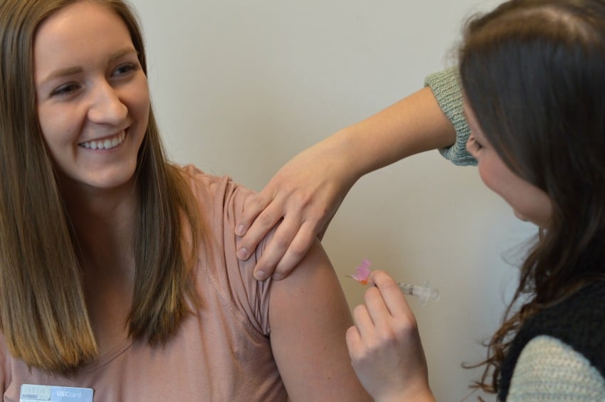 <who> Photo Credit: UBCO </who> UBC Okanagan nursing student Sarah Buchsbaum receives her flu shot from fellow student Talia Fraser.