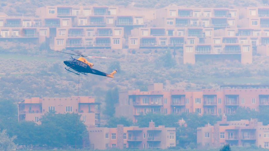 <who>Photo Credit: NowMedia</who> The evacuated Spirit Ridge Resort in the background, a helicopter pulls water from Osoyoos Lake