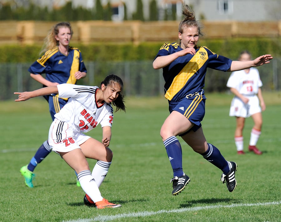 Abigail Taneda, left, watches as her shot sails toward the OKM net.