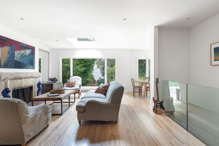 A beautiful living room with a sneaky little view of the ocean in the background.