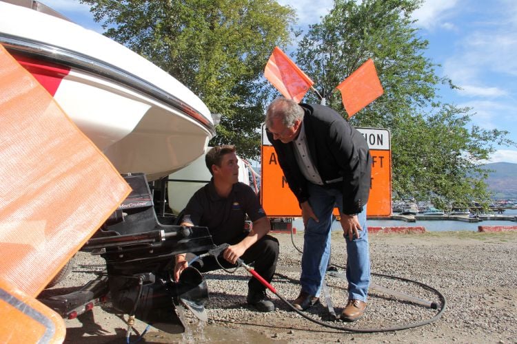 Minister Steve Thomson checking out how to inspect a boat for invasive mussels. (Photo Credit: KelownaNow.com.)