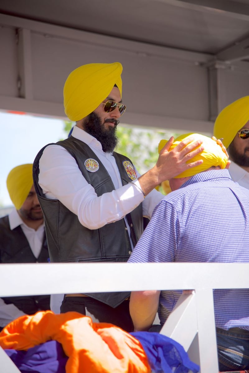 <who>Photo Credit: Savannah Bagshaw / KelownaNow</who> Parade watchers could wait in line to go onto this float to get a bright yellow turban wrapped. 
