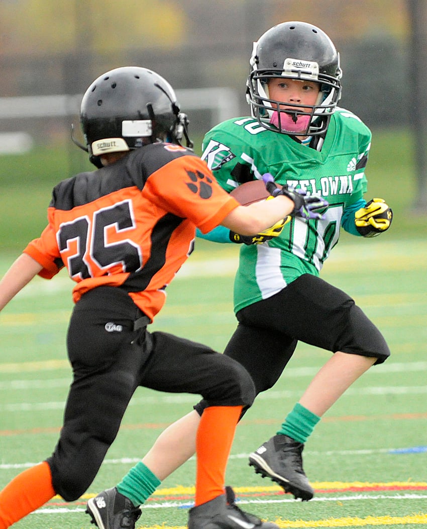 <who>Photo Credit: Lorne White/KelownaNow </who>Quinn Kayfish, quarterback of the Kelowna Riders, looks for some room to run against the Kelowna Lions' Finlay Peters.