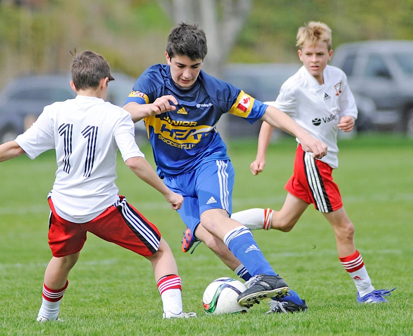 <who>Photo Credit: Lorne White/KelownaNow </who>Ben Burton of the KU/Junior Heat makes his move against United's Eli Harris, left, in a recent TOYSL game at Parkinson Sportsfields. In support is United's Jack Millikin.