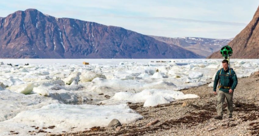 <who>Photo Credit: Parks Canada/Ryan Bray</who>Parks Canada staff walking along the shoreline of Grise Fiord, carrying Google Trekker. 