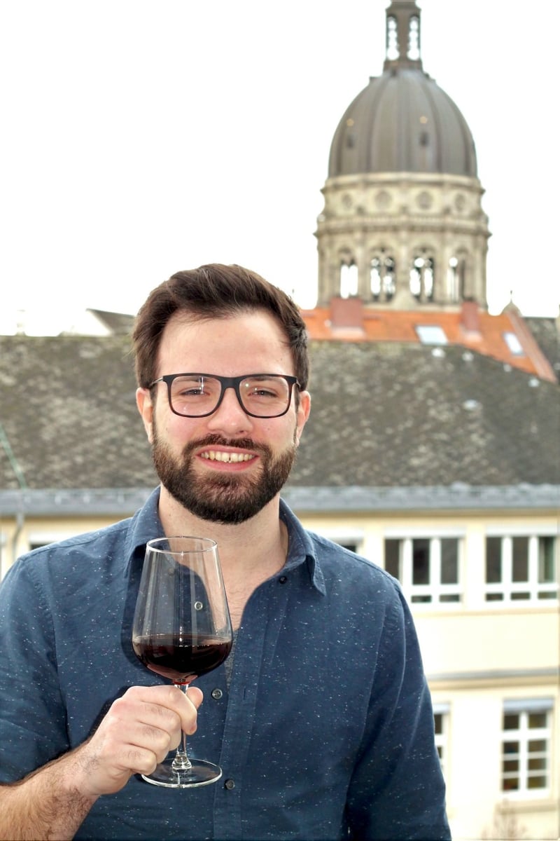 <who> Photo Credit: Okanagan College </who> Tim Allgaier enjoys a glass of B.C. Pinot Noir back in his hometown in Germany. 