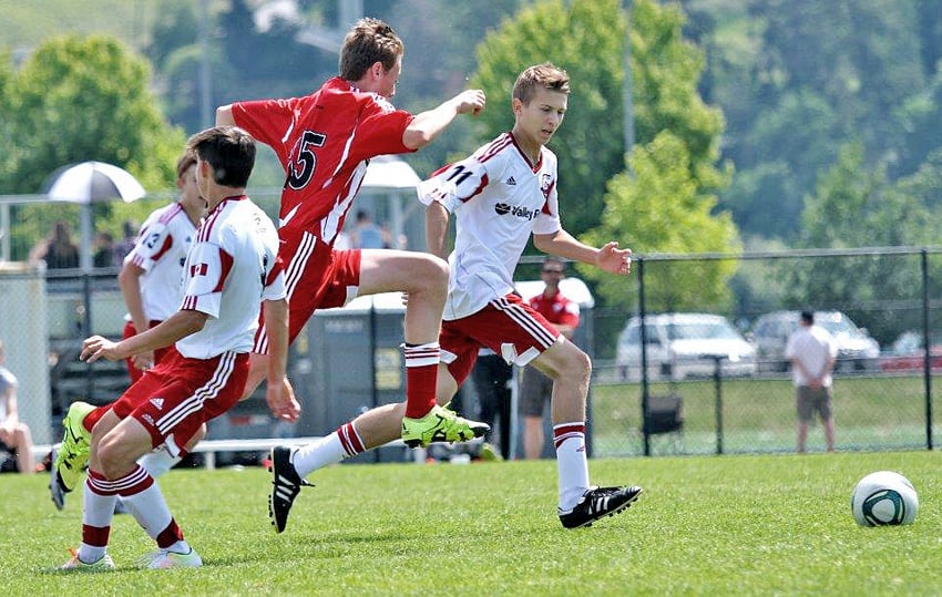 <who>Photo Credit: Contributed </who>Chris VanDenHeuvel jumps between defenders in an attempt to continue on the offence.