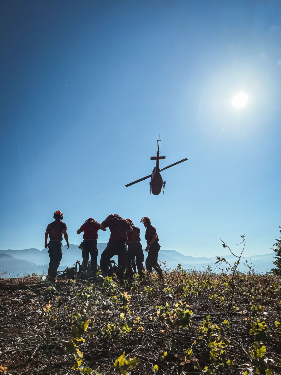<who>Photo Credit: BCWS</who>Personnel get dropped off at the worksite by helicopter in the morning.