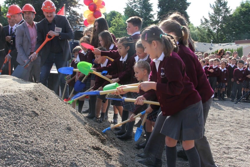 <who> Photo Credit: KelownaNow. </who> Mayor Colin Basran and head builder Mike Jacobs help St. Joseph's students break ground for their new school. 