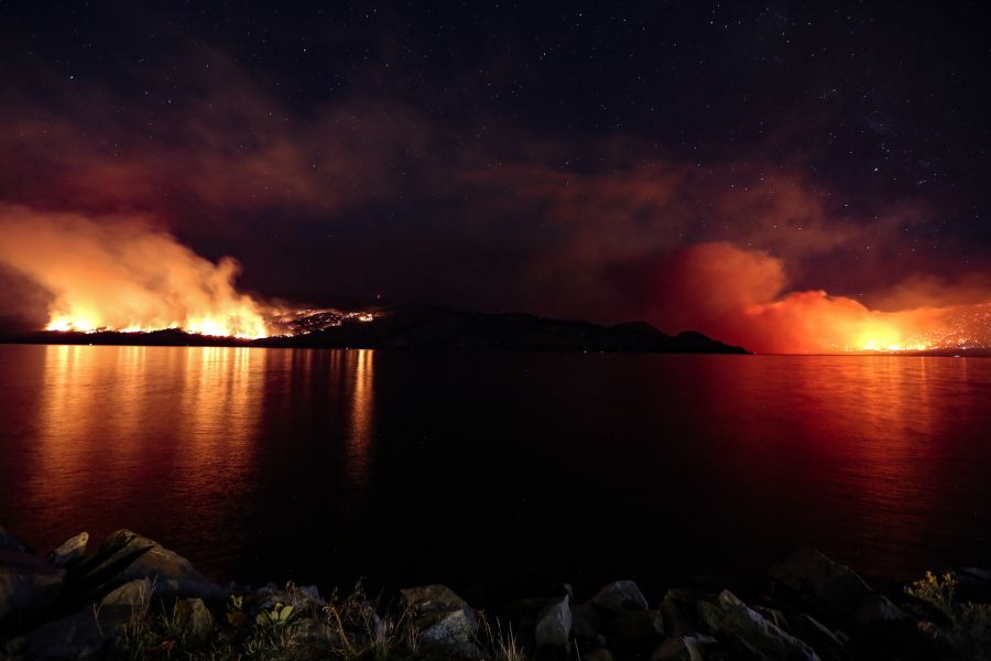 <who>Photo Credit: KelownaNow</who>The Good Creek wildfire (left) and the Mount Eneas wildfire (right) burn in the night.