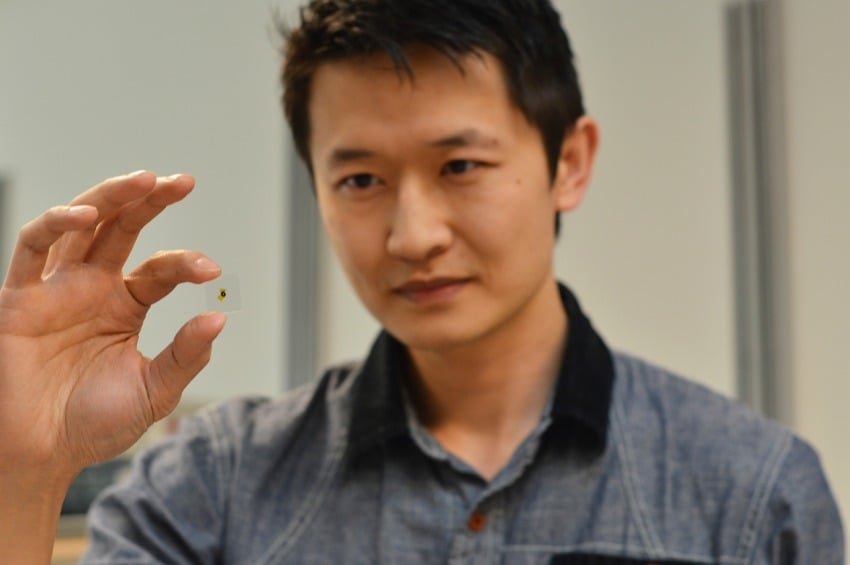 <who> Photo Credit: UBCO </who> UBC's Kenneth Chau holds a glass sample used in his latest research, which proved that putting thin layers of metal over glass increases light transmission. 