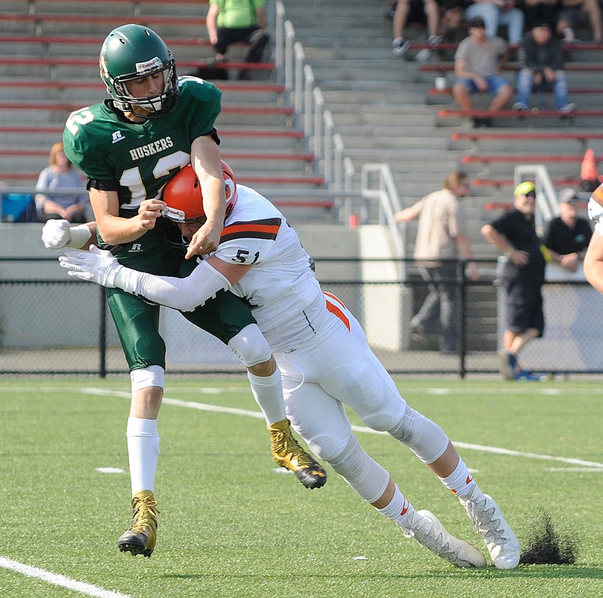 <who>Photo Credit: Lorne White/KelownaNow </who>The Sun's Gavin Kulscar puts a hard hit on Valley Huskers' quarterback Nicolae Nica after he releases a pass in the fourth quarter of Saturday's game in Chilliwack.