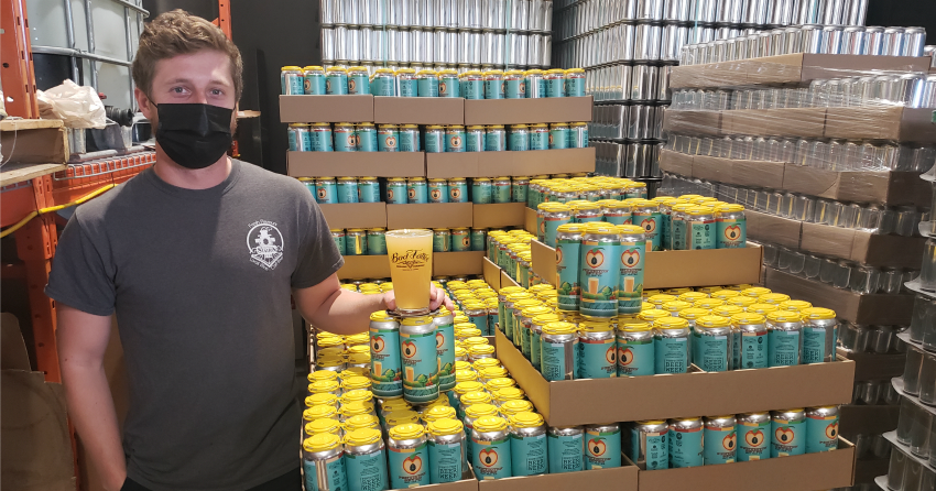 <who> Photo Credit: NowMedia </who> Bad Tattoo head brewer Liam Hutcheson shows off the Hazy Pale Ale, a collaboration beer brewed at Bad Tattoo.