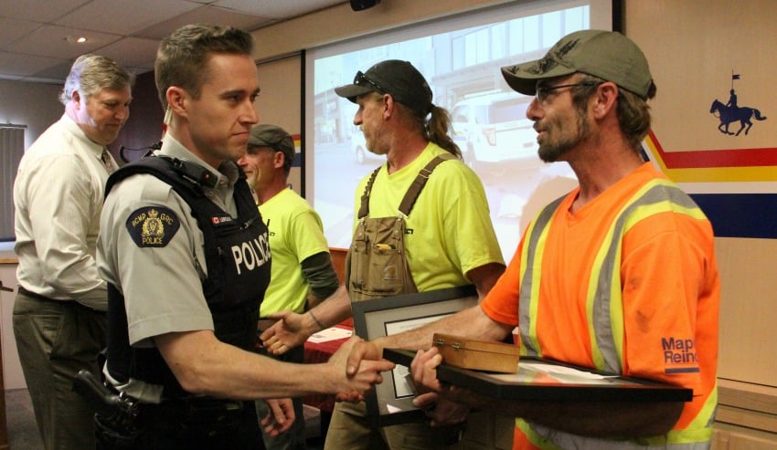 <who> Photo Credit: KelownaNow. </who> Many people gathered at the RCMP detachment to thank the men for their help. 