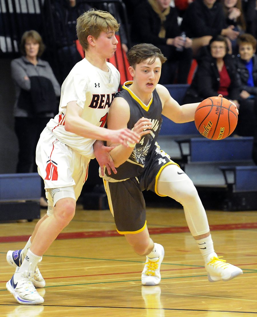 Malcolm Greggor, right, of the Kelowna Owls drives to the paint against Boucherie's Josh Clancy.