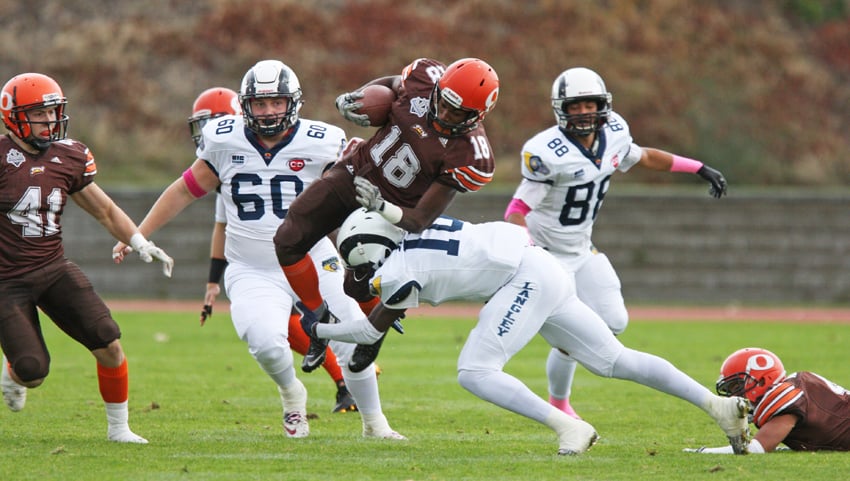 <who>Photo Credit: Chris Stanford/KelownaNow </who>Raquille Cespedes of the Okanagan Sun goes flying high over the tackle of Seye Akinsanmi of the visiting Langley Rams during first-half action of their BCFC semi-final game at the Apple Bowl on Sunday.